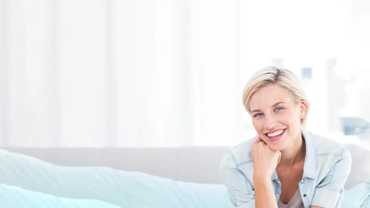 a woman smiling with her hand on her chin
