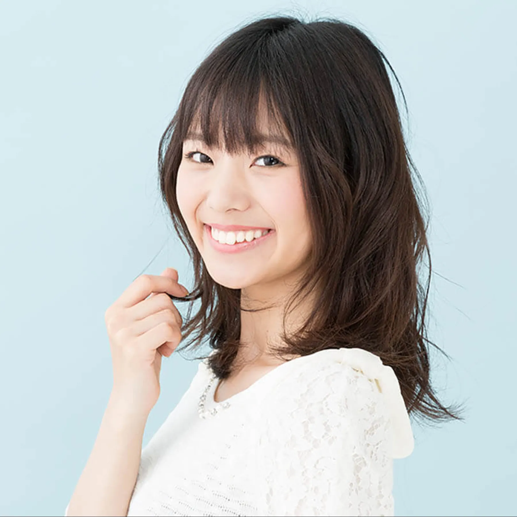 a woman smiling and holding a pen