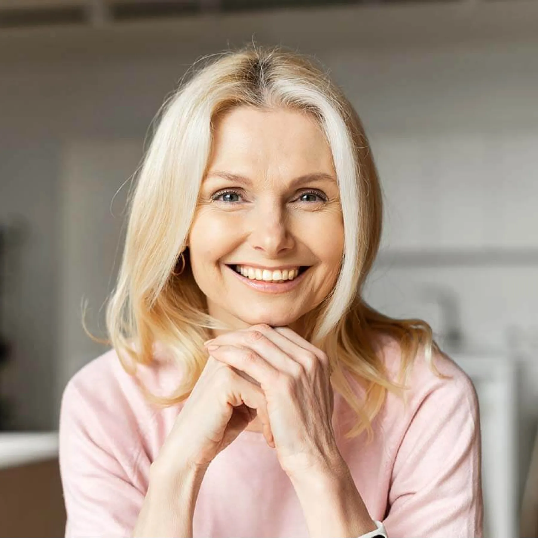 a woman smiling with her hand on her chin