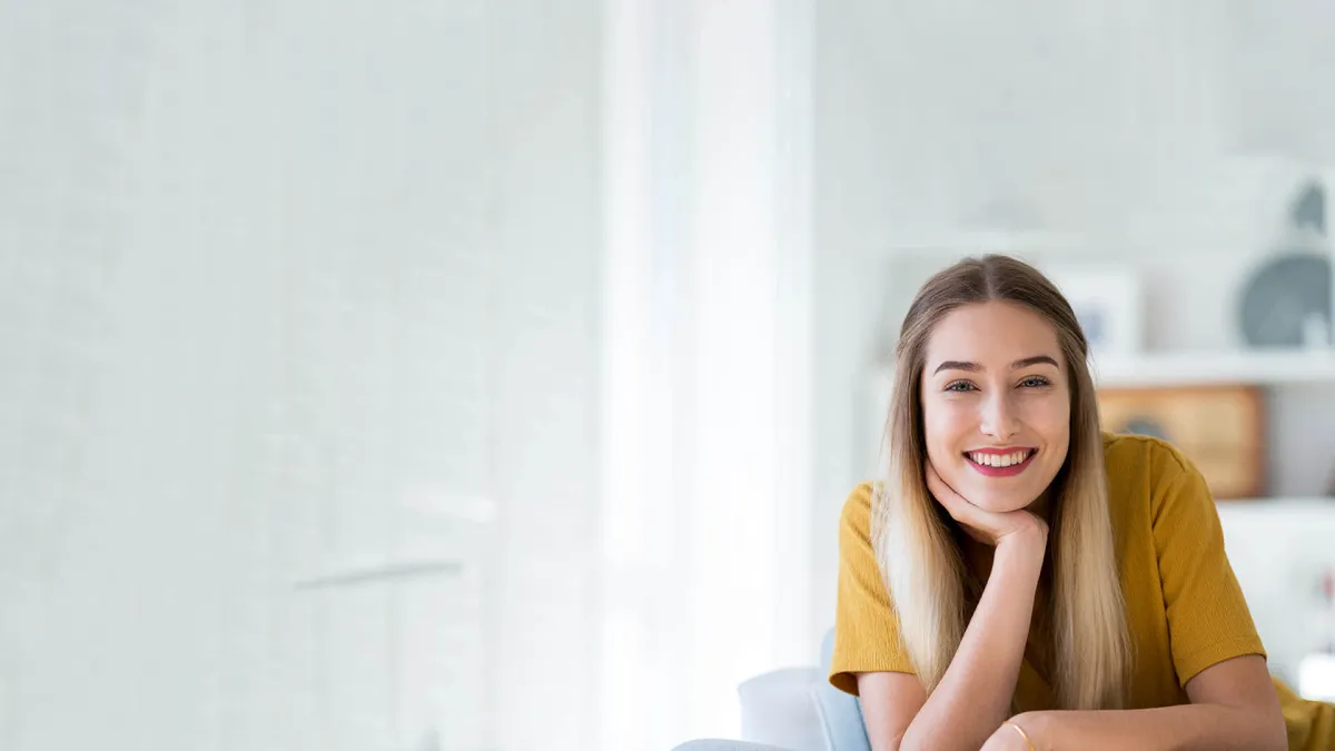 a woman smiling with her hand on her chin