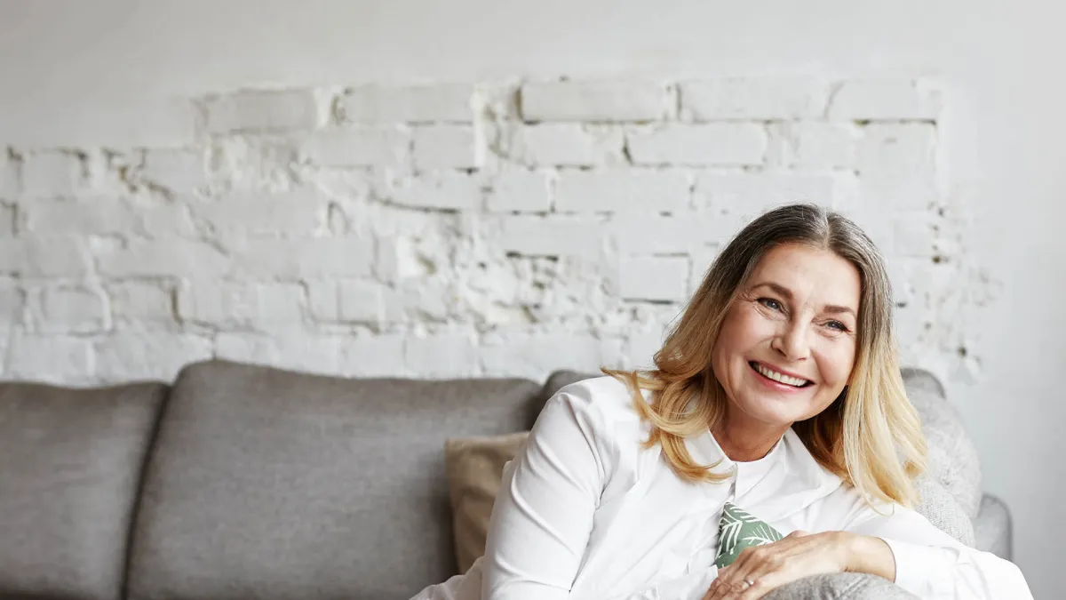 Charlotte Rampling sitting on a couch